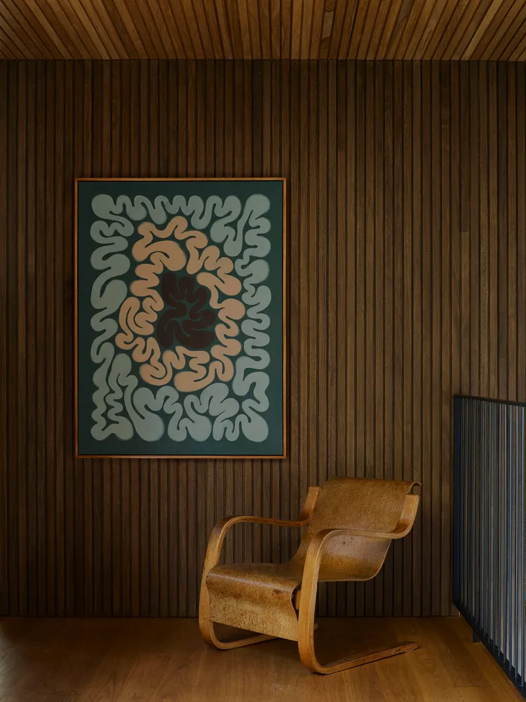 A modern interior space featuring a wooden wall with a textured wall panel and a wooden chair.