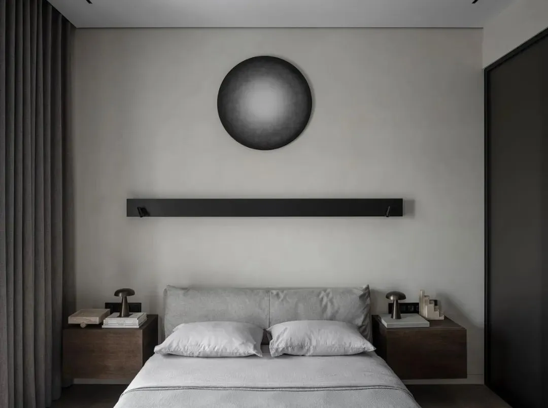 A minimalist bedroom featuring a bed with bedside lamps and minimalist decor.