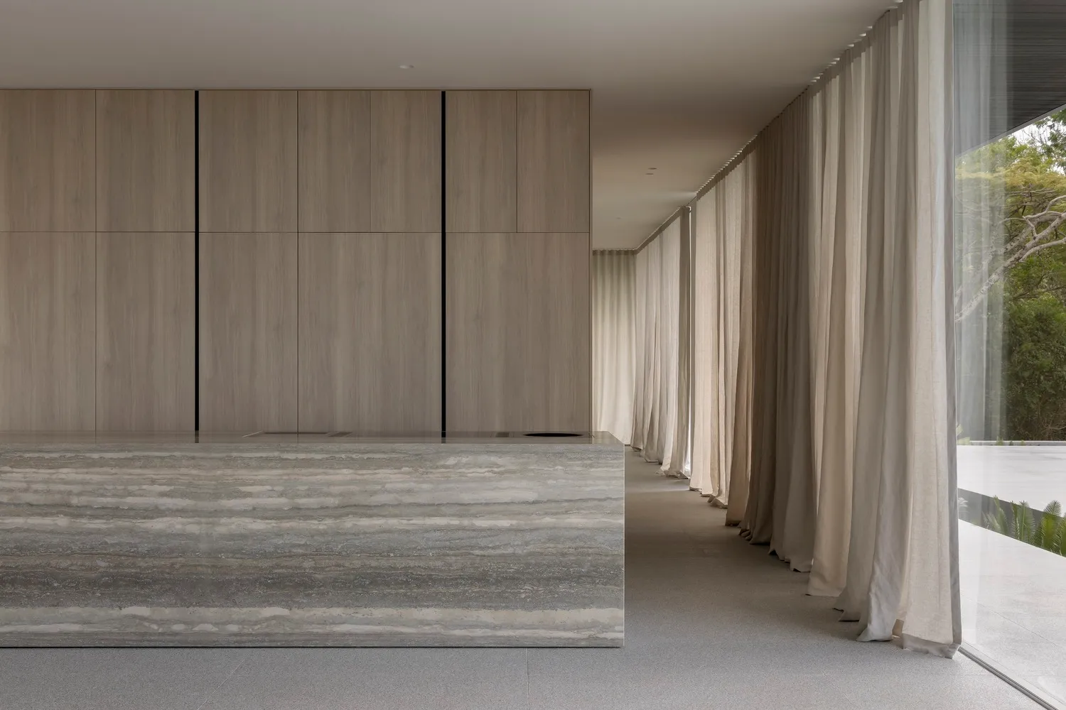 Modern lobby with glass walls and floor, featuring a minimalist design.