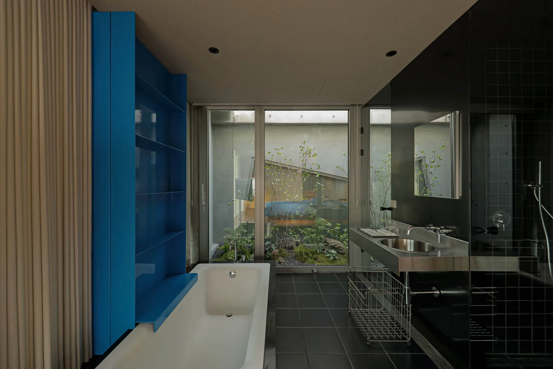 A modern bathroom with glass walls and a white bathtub.