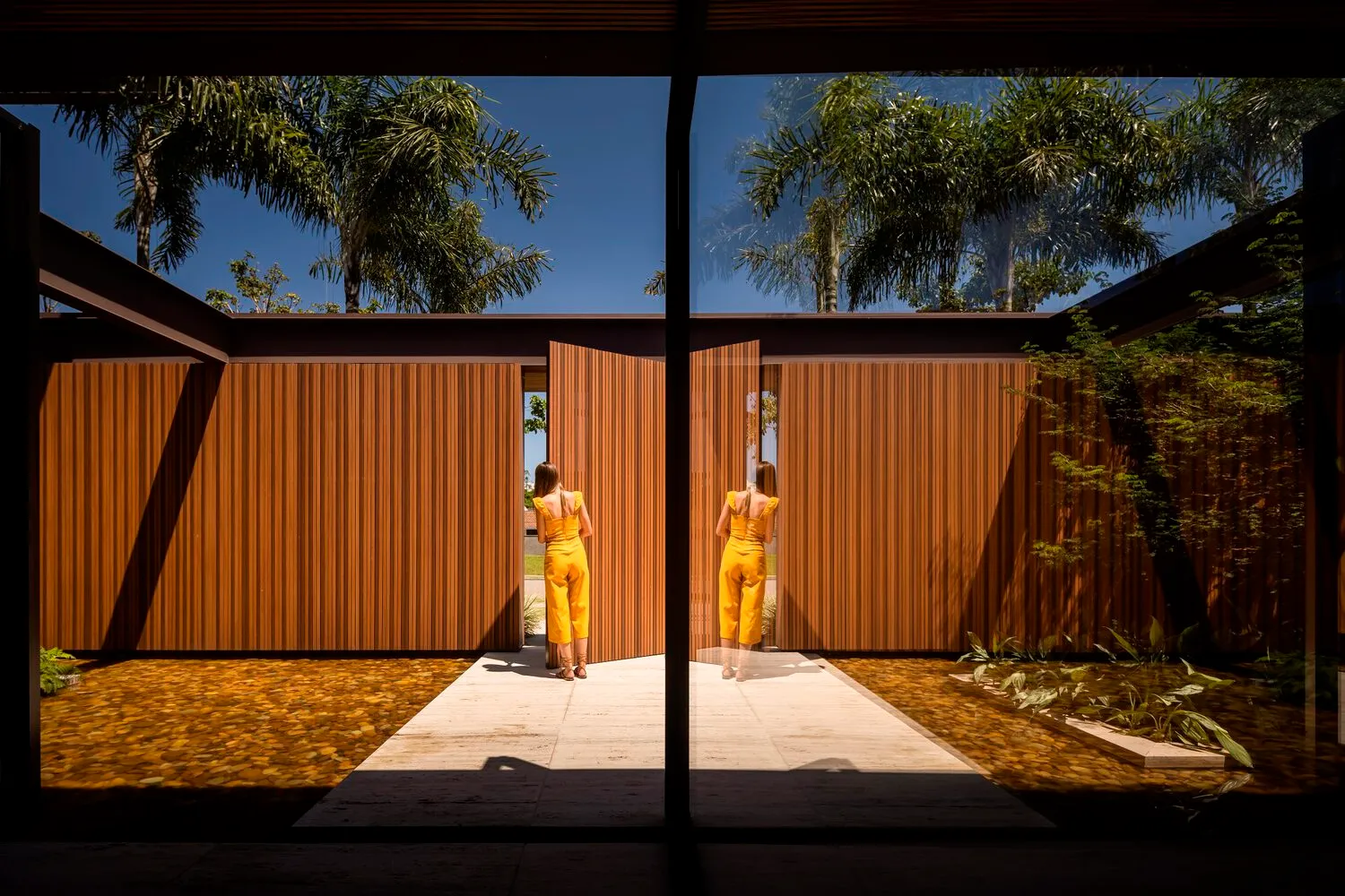 A modern architectural design featuring wooden walls and a concrete pathway.