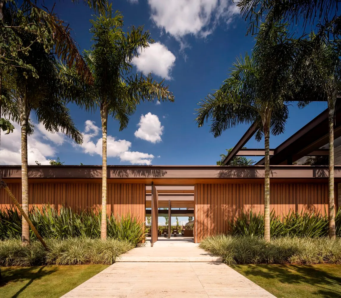 Modern residential exterior with tropical landscaping and wooden elements.