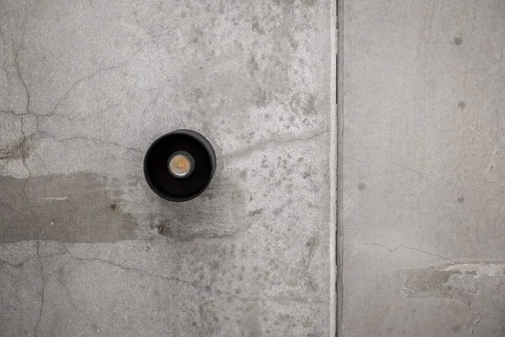 Industrial light fixture mounted on a concrete wall.