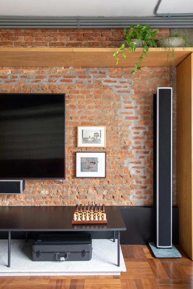 Living room with exposed brick walls, wooden floor, and modern furniture
