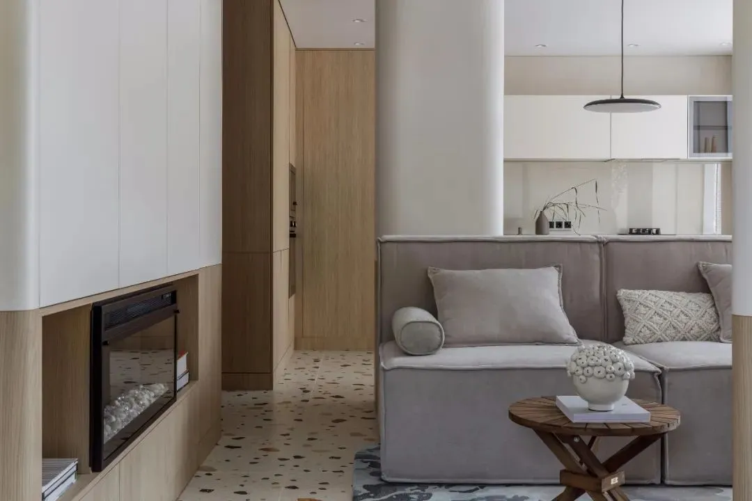 Modern minimalist living room with a terrazzo cement floor, upholstered sofa, and a built-in fireplace