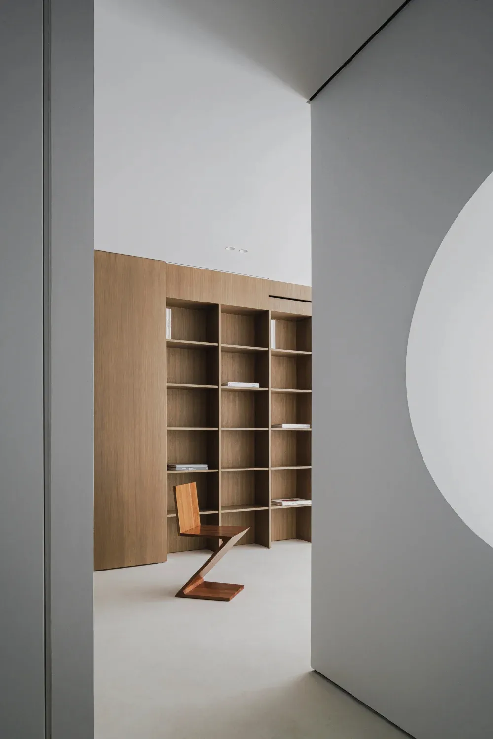 A modern library with wooden walls and shelves.