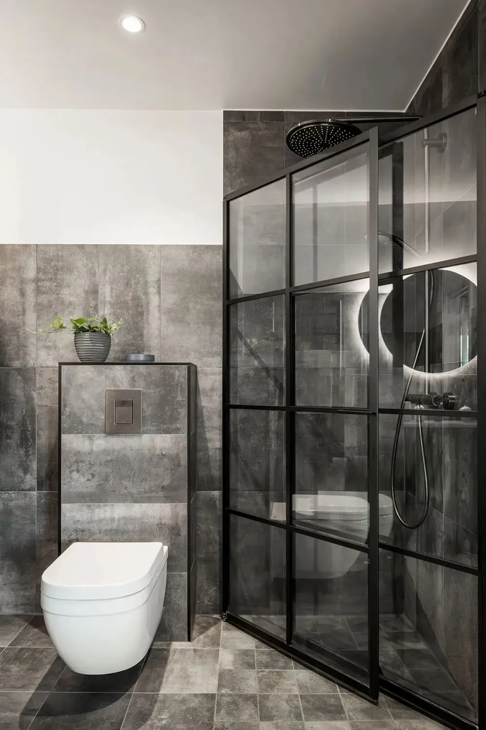 Modern minimalist bathroom with concrete tiles and a white toilet.
