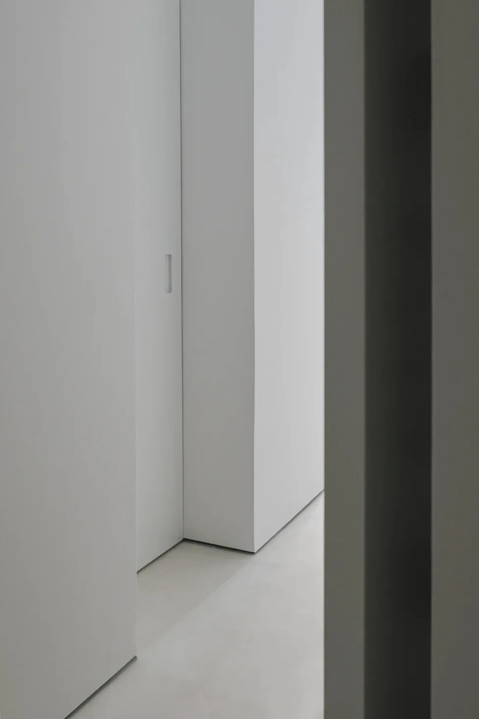 A minimalist bedroom with concrete walls and floor.