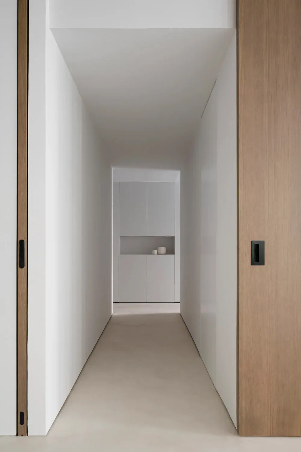 A minimalist corridor with wooden walls and a concrete floor.
