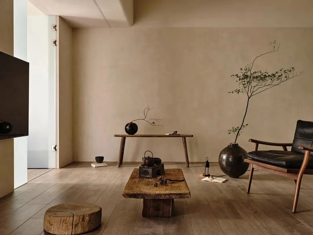 A minimalist living room with wood furniture and shelves.