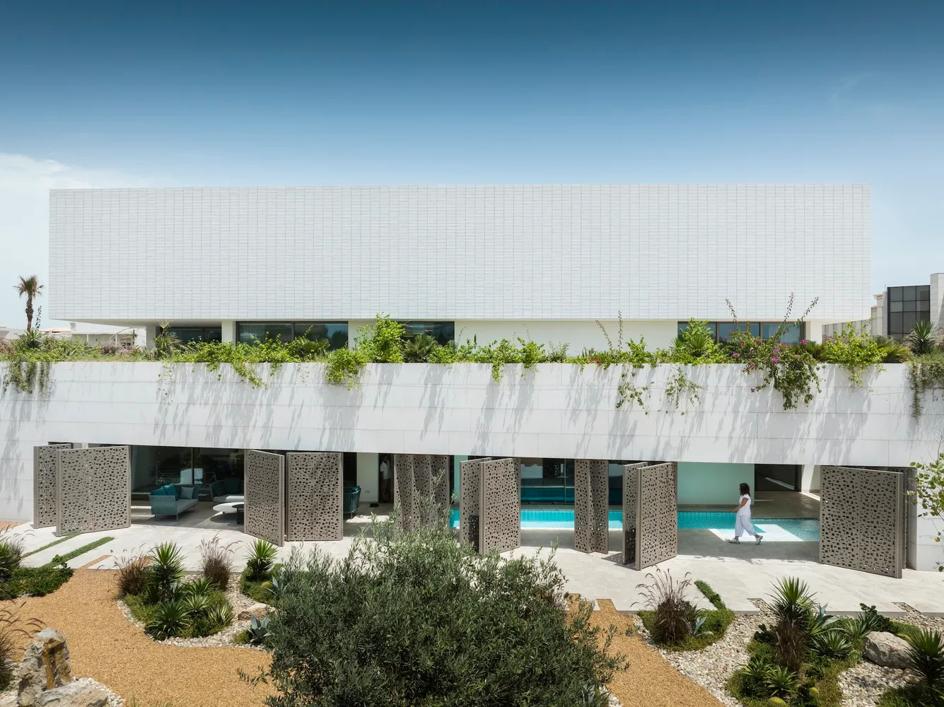 A modern residential house featuring a minimalist design with a white exterior.