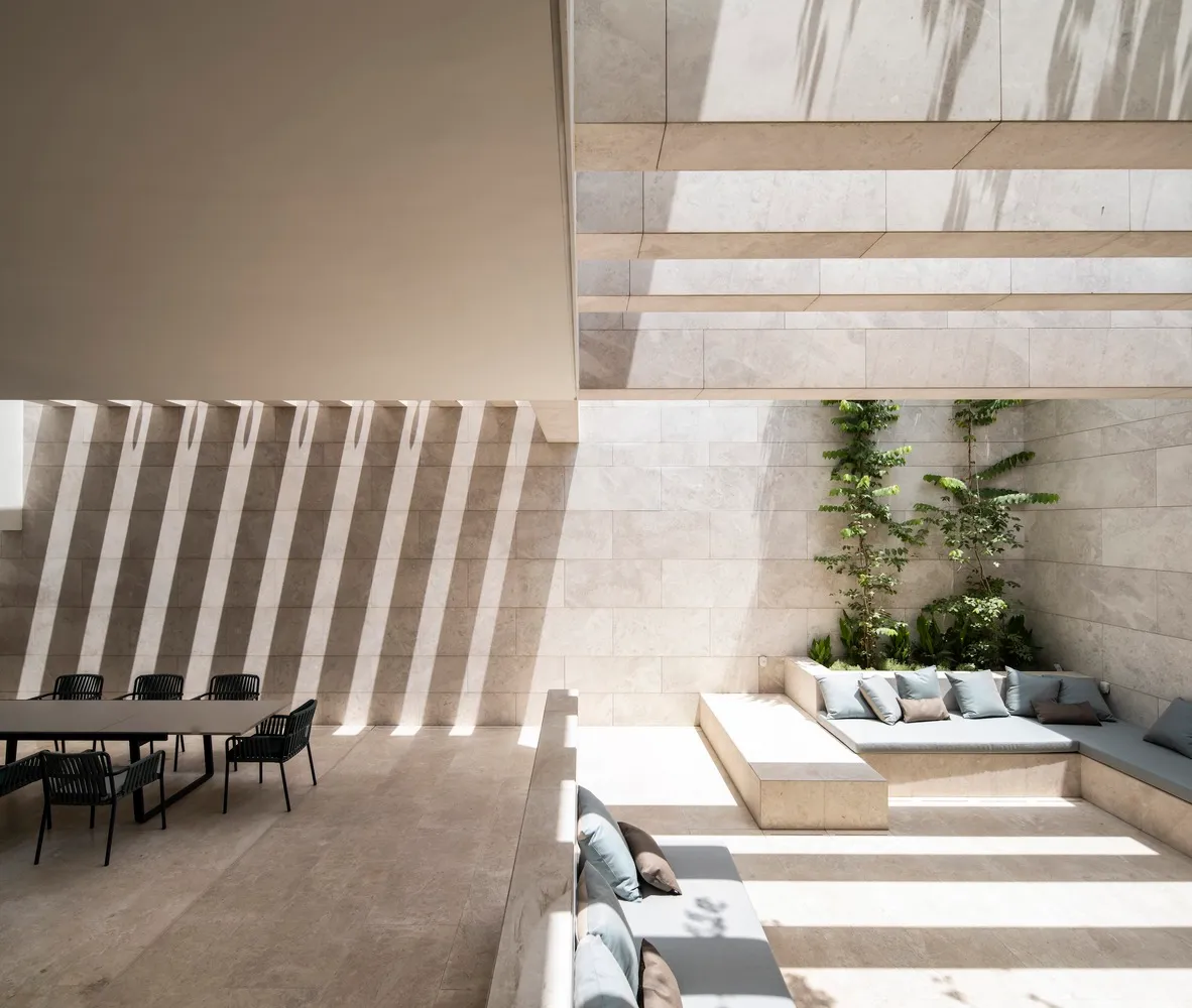 A modern minimalist living space featuring light-colored tiles and marble materials.