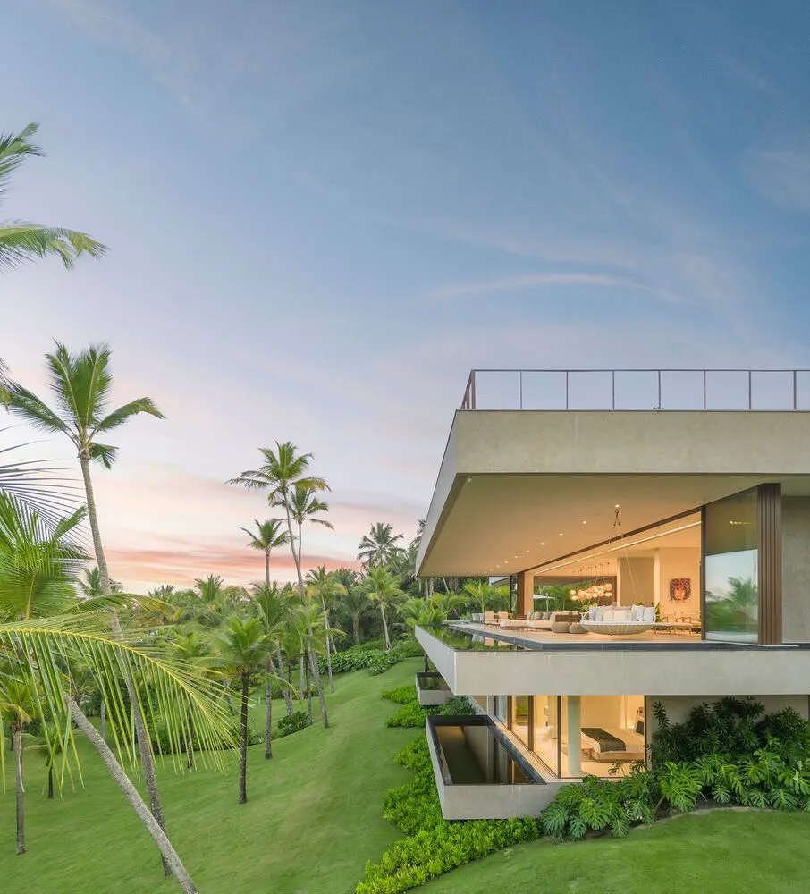 Modern, minimalist house with concrete and glass exterior materials, viewed from the side.