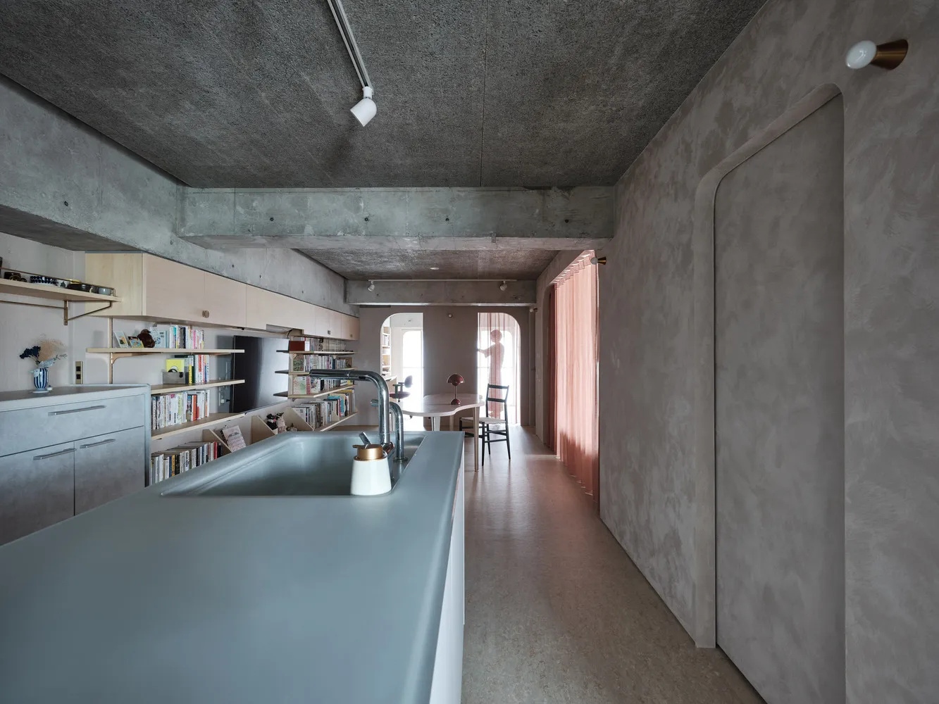 Contemporary kitchen area with concrete countertops and minimalist design.