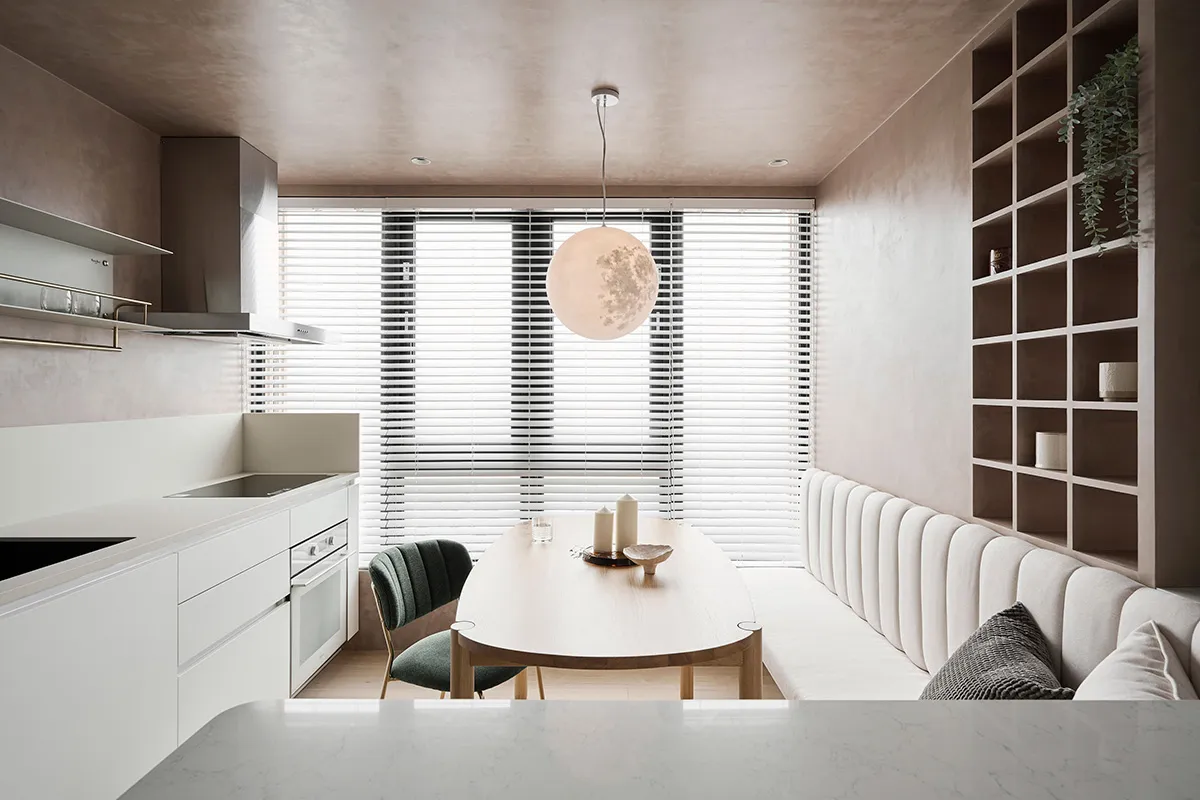A modern kitchen and dining area with minimalist design elements and a sleek, white color palette.