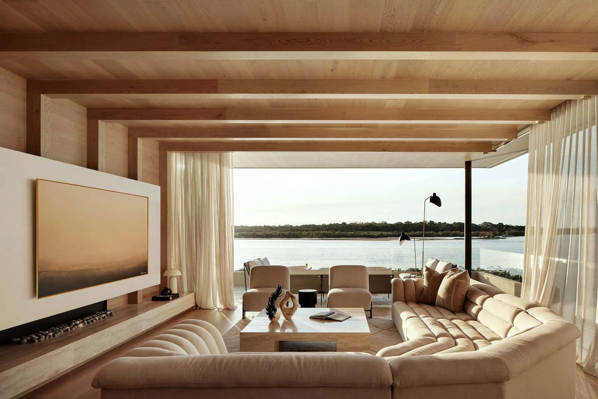 A modern living room featuring a textured sofa with large windows overlooking a scenic view.