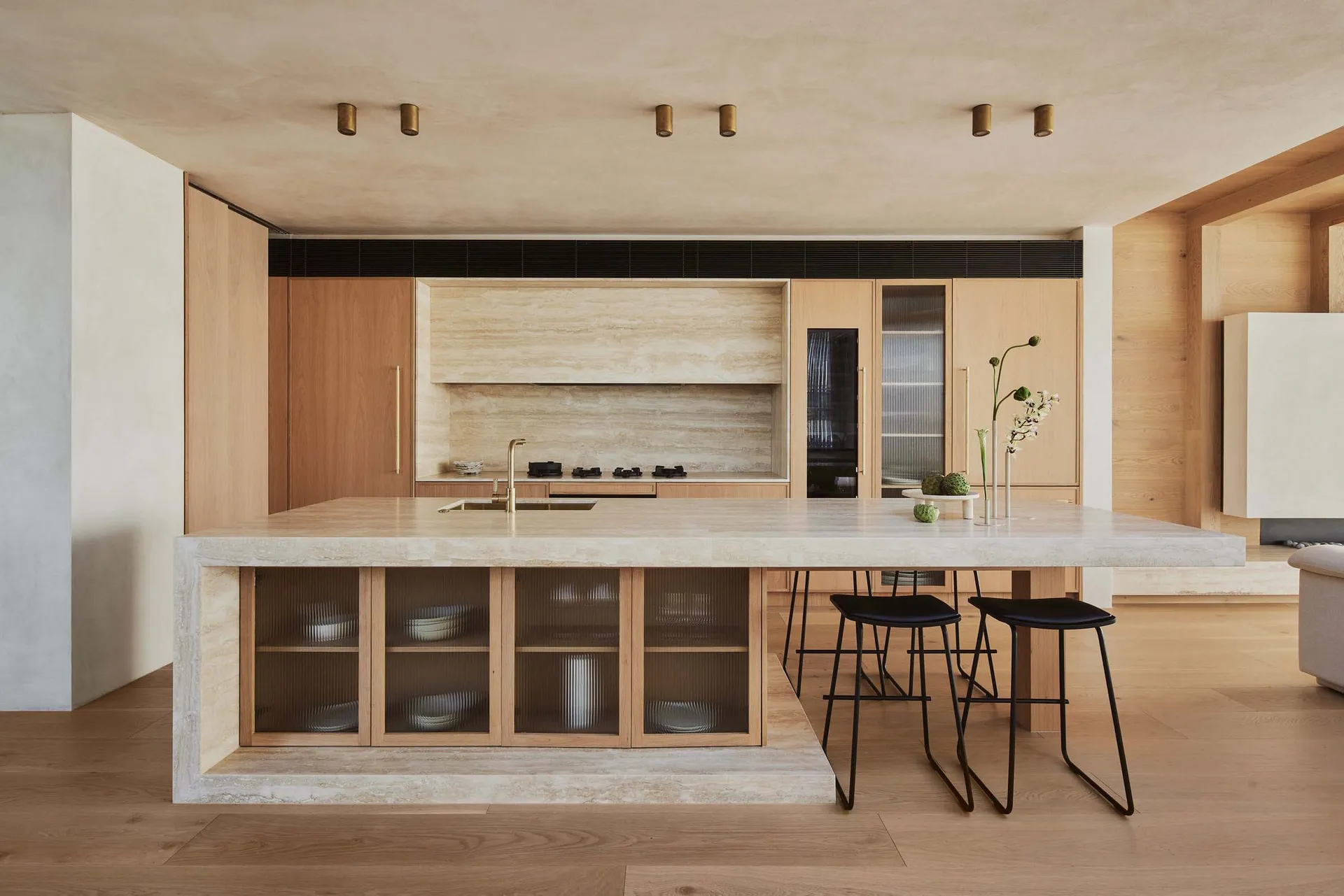 A modern residential kitchen with marble countertops and wooden cabinets