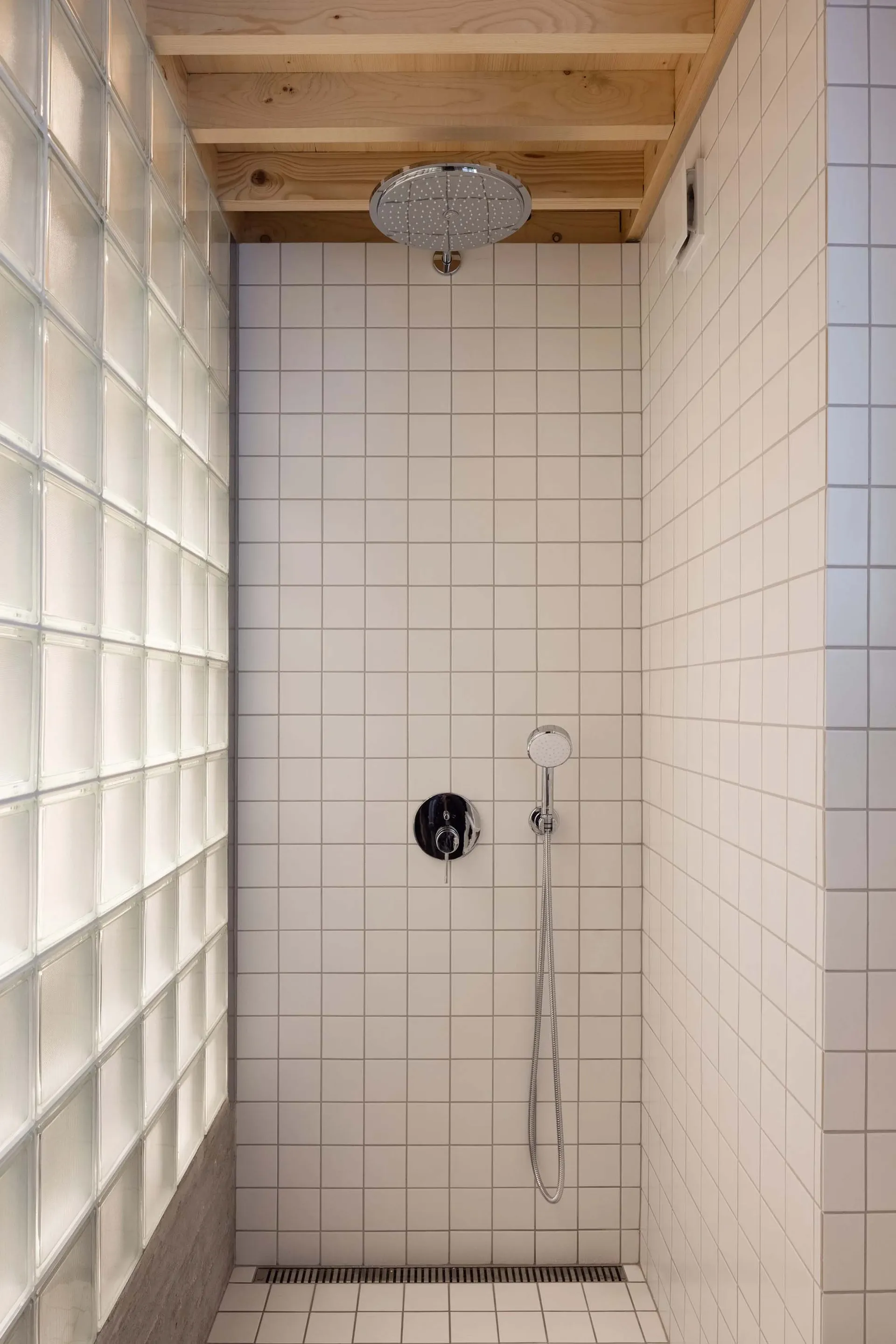 A modern shower with glass blocks and minimalist tile design.