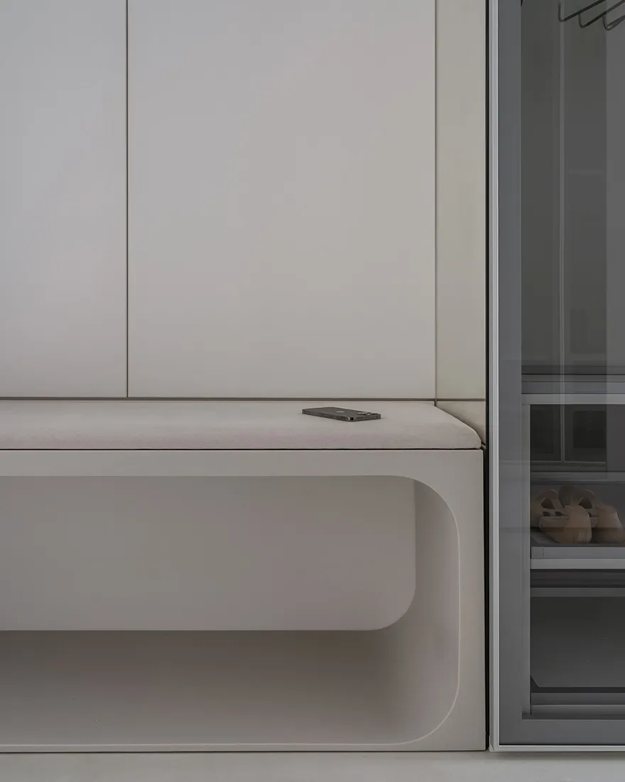 A minimalist entryway with a concrete bench and wardrobe.