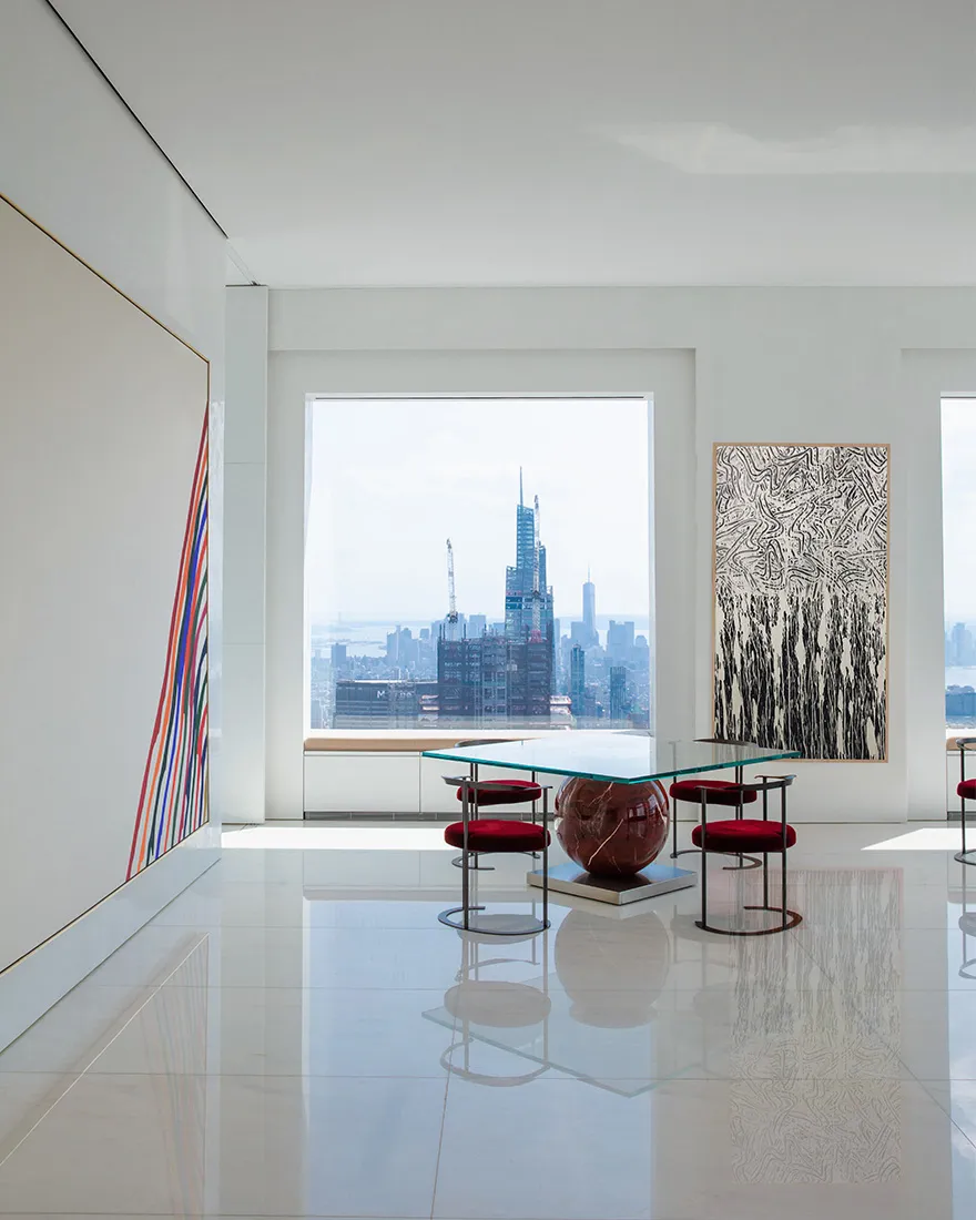 A modern living room featuring marble finishes and a panoramic city view.