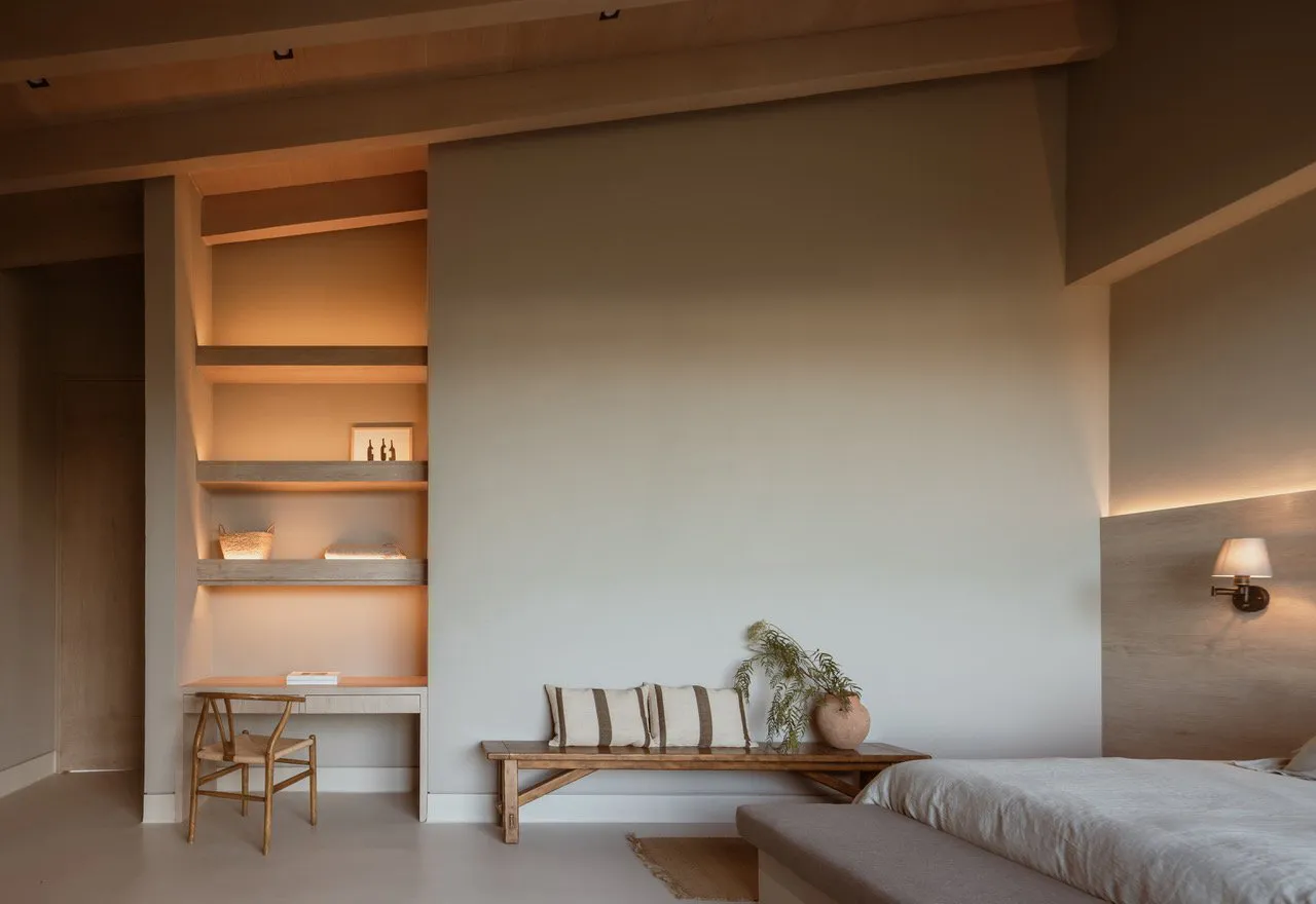 A minimalist bedroom with a rock wall, concrete floor, and ambient lighting.