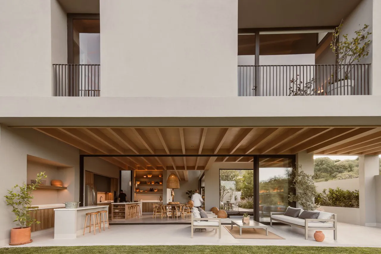 Modern minimalist living room with concrete walls and floor, natural light, and sleek furniture.