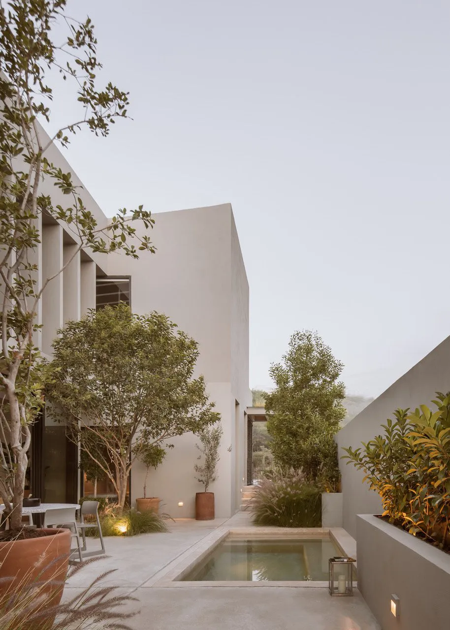 A modern house with a minimalist exterior in concrete and greenery.