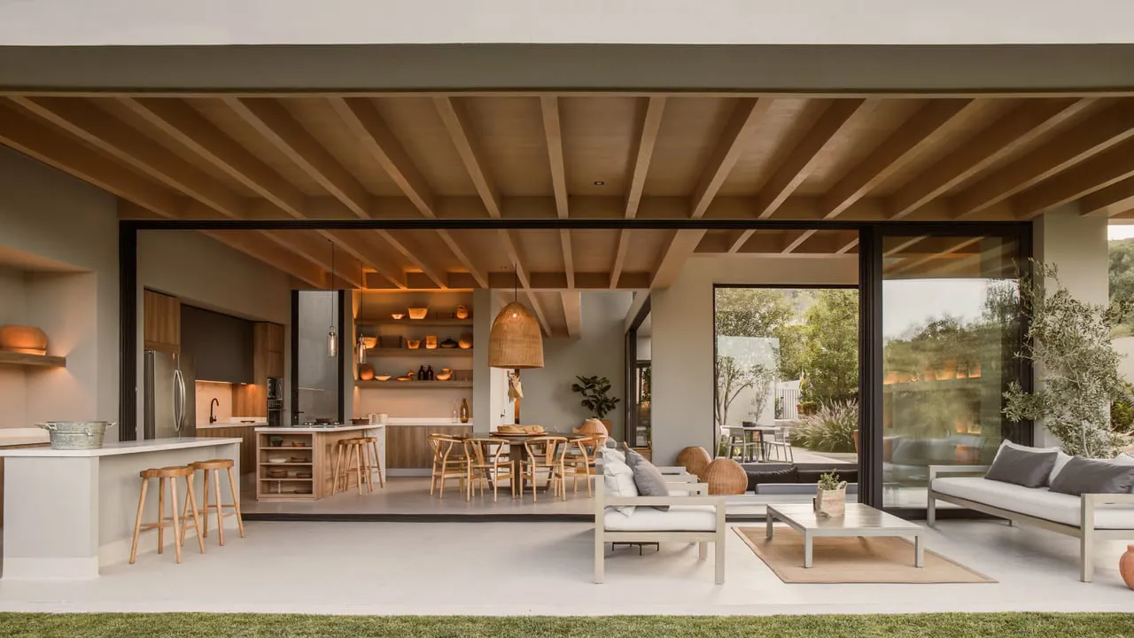 A modern residential living space featuring wooden walls, floors, and furniture, with an open-concept design that blends indo