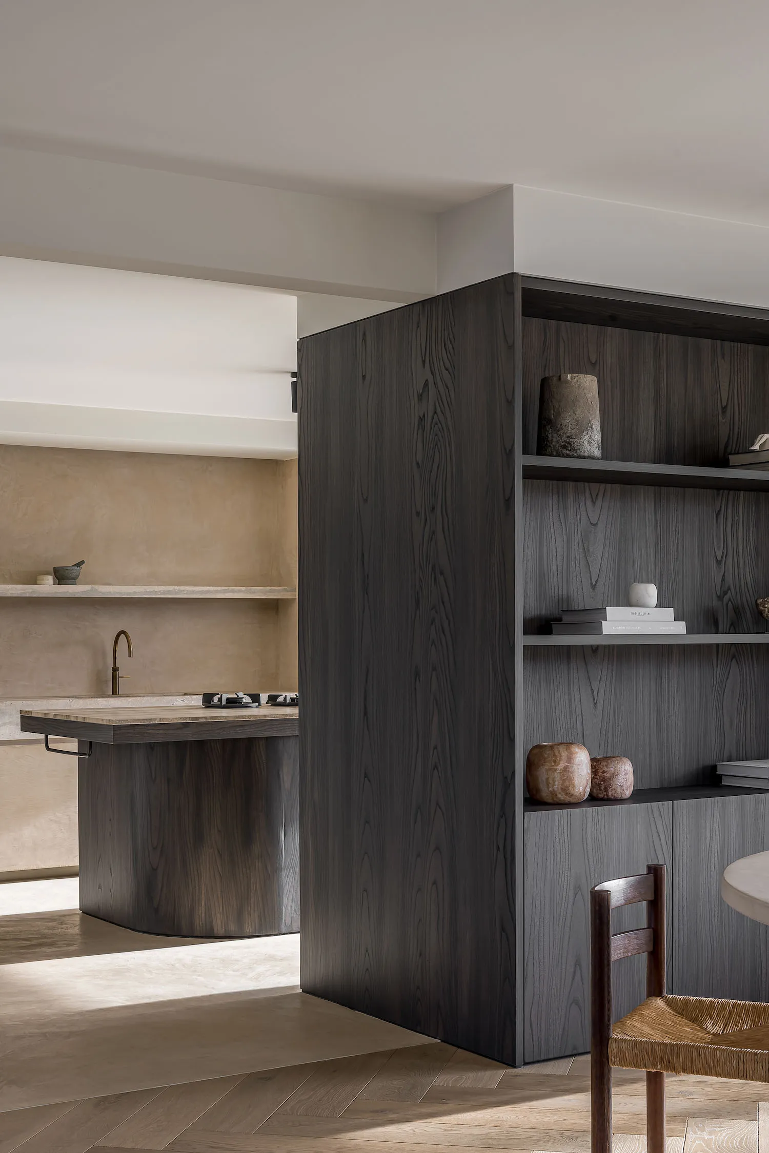 Modern, minimalist residential kitchen featuring dark wood cabinets and open shelving.