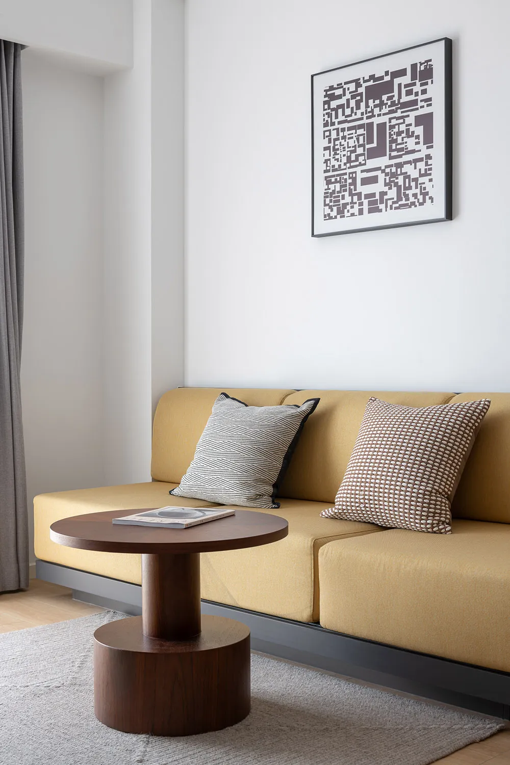 Modern living room with a yellow sofa, gray curtains, and white walls.