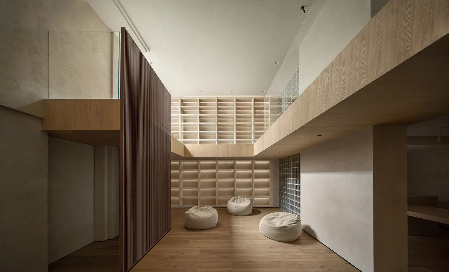 A minimalist library with wooden shelves and seats.