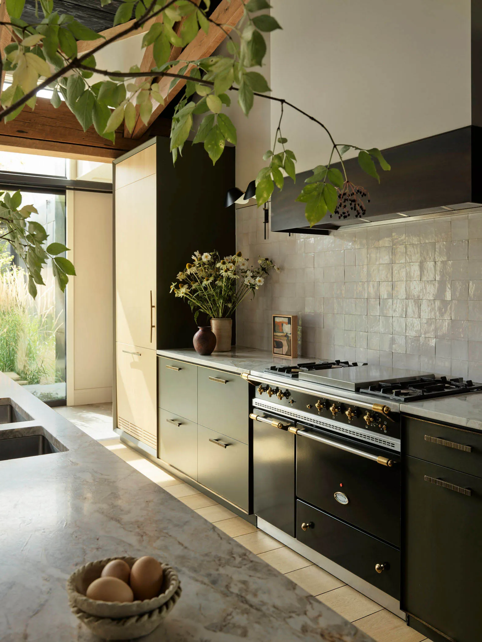 A modern kitchen featuring marble countertops and cabinets adorned with metal accents.