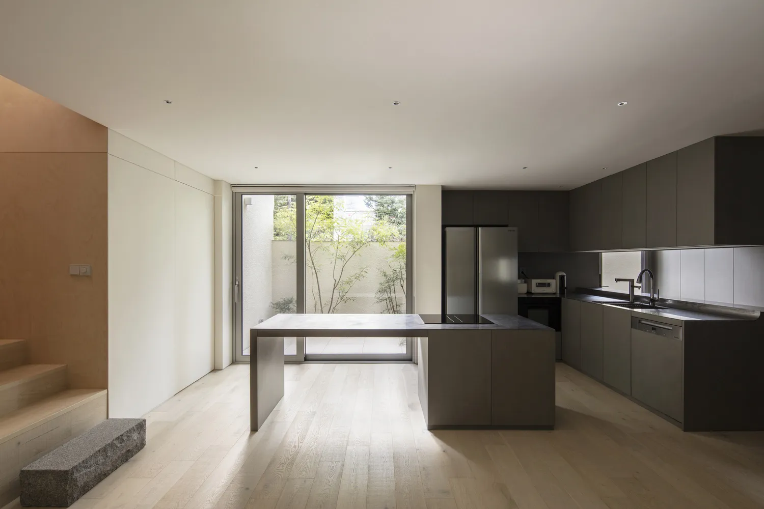 Modern kitchen with wooden flooring and minimalist design features.