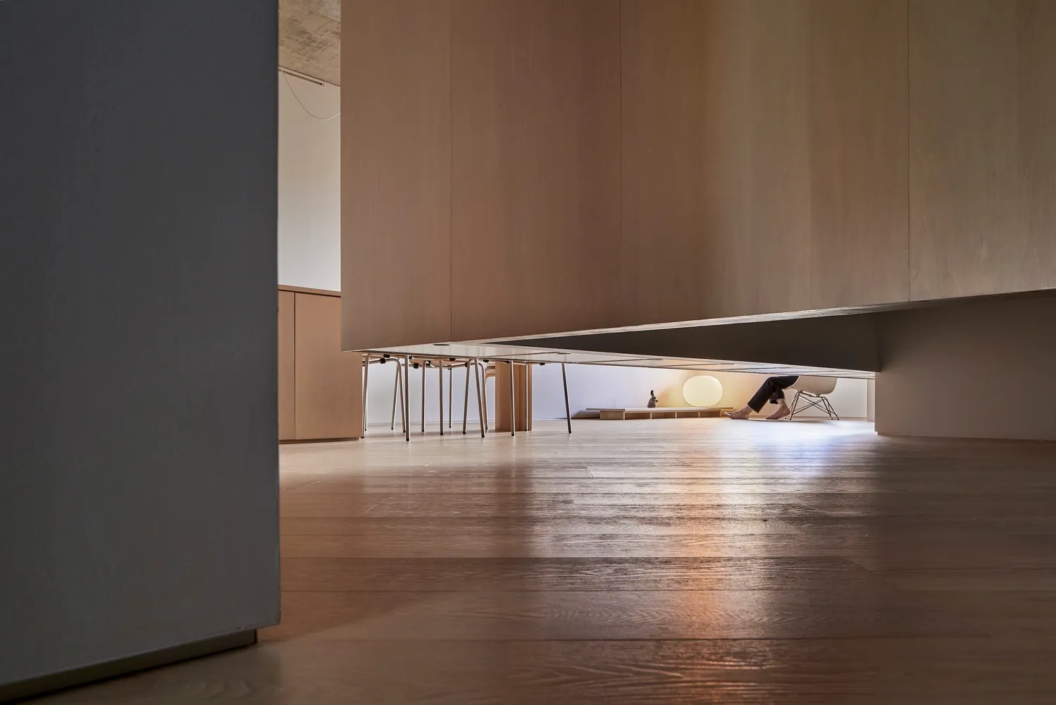 A modern living room featuring minimalist furniture in warm wood tones.