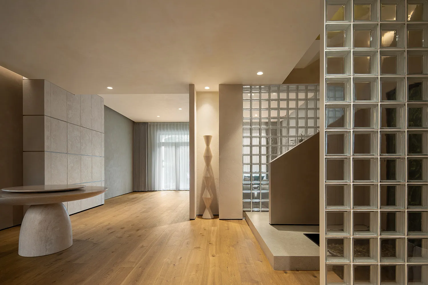 現代住宅室內,展現硬木地板、混凝土牆面與玻璃磚。
