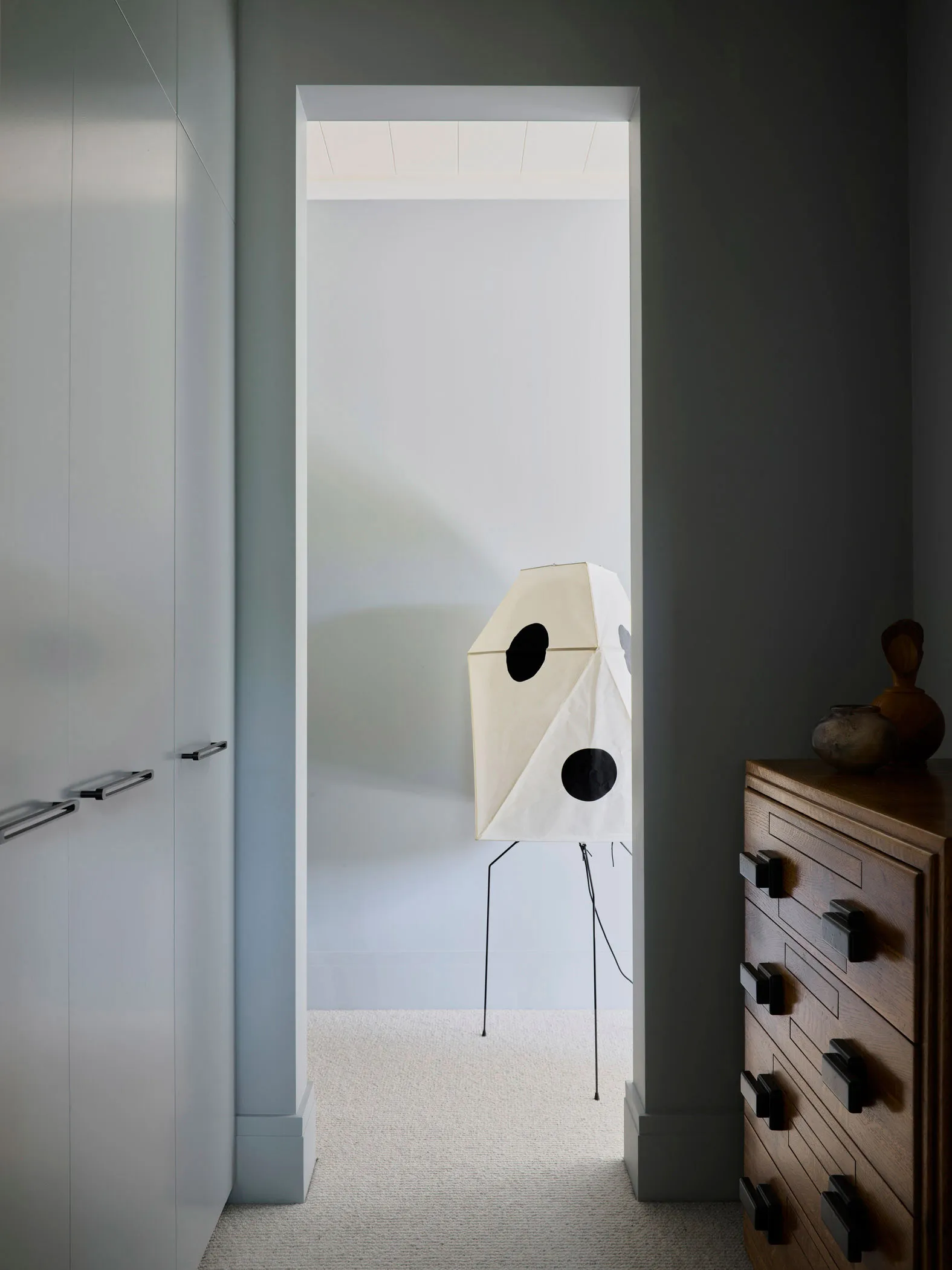 A minimalist interior space featuring a fabric screen with black circles.