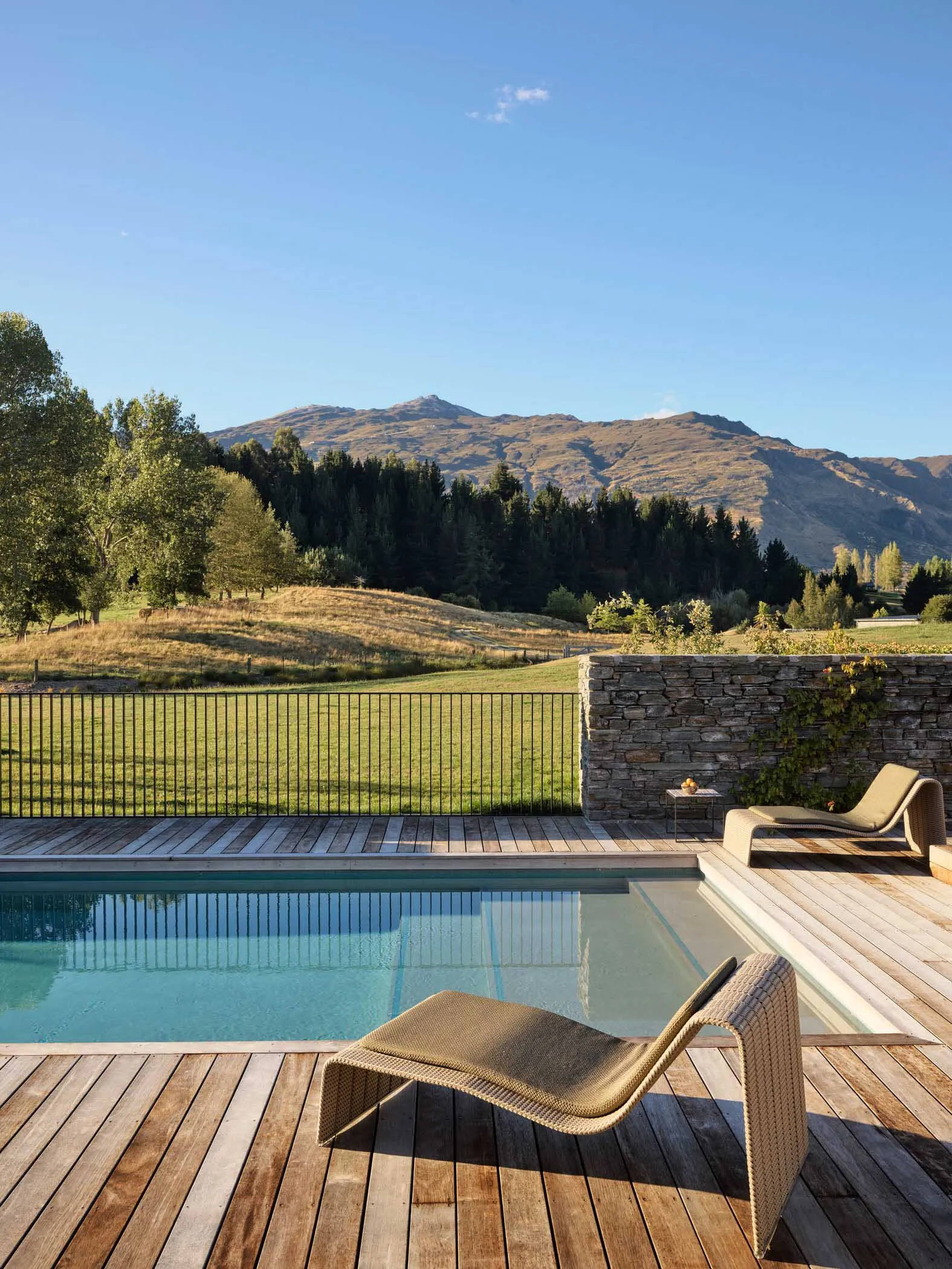 A modern residential patio featuring wood, stone, and metal elements.
