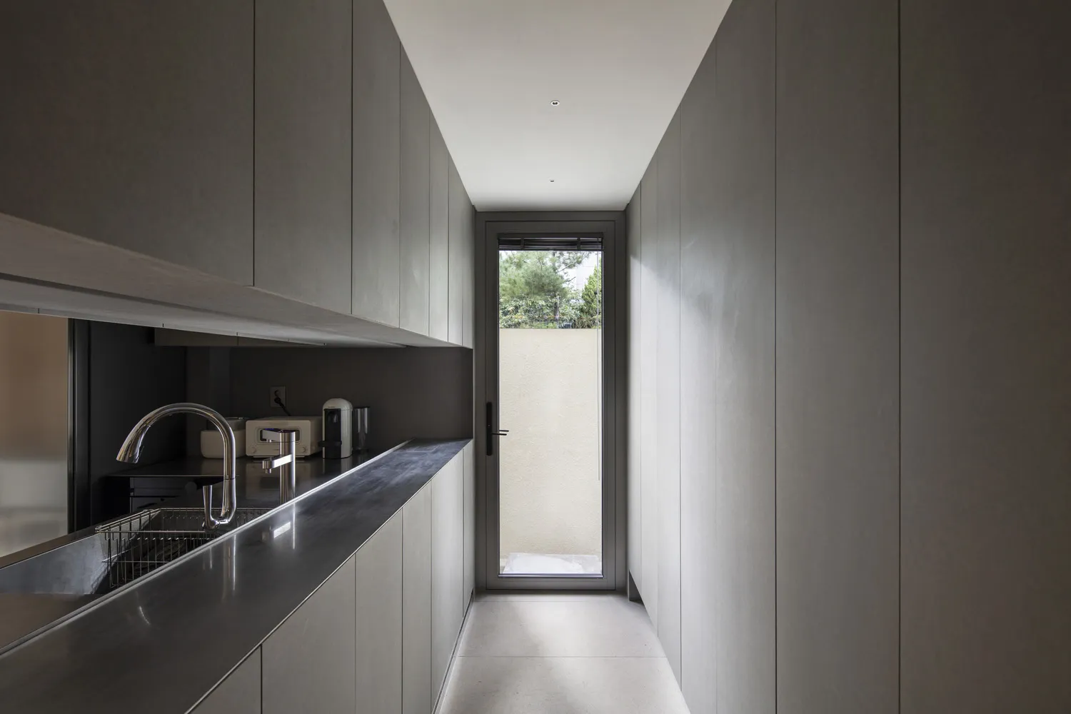 A sleek, modern kitchen with metallic countertops and minimalist design.