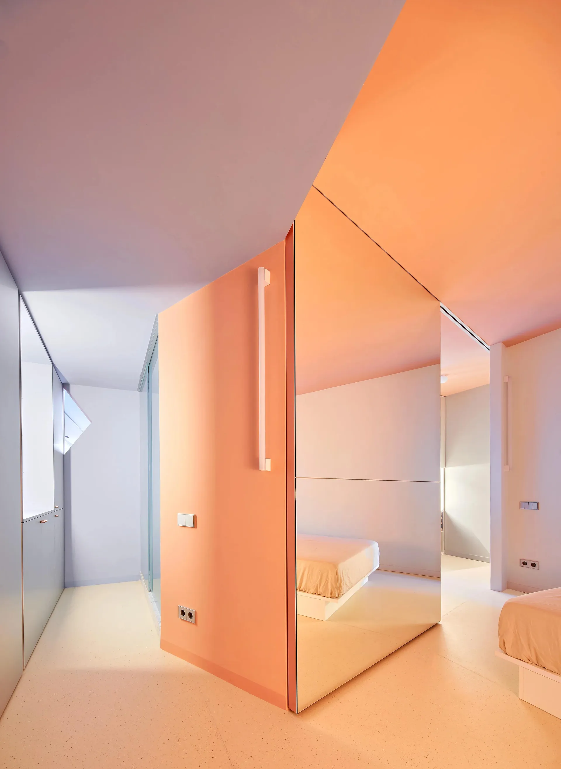 Modern minimalist bedroom featuring orange painted surfaces and large mirrors.