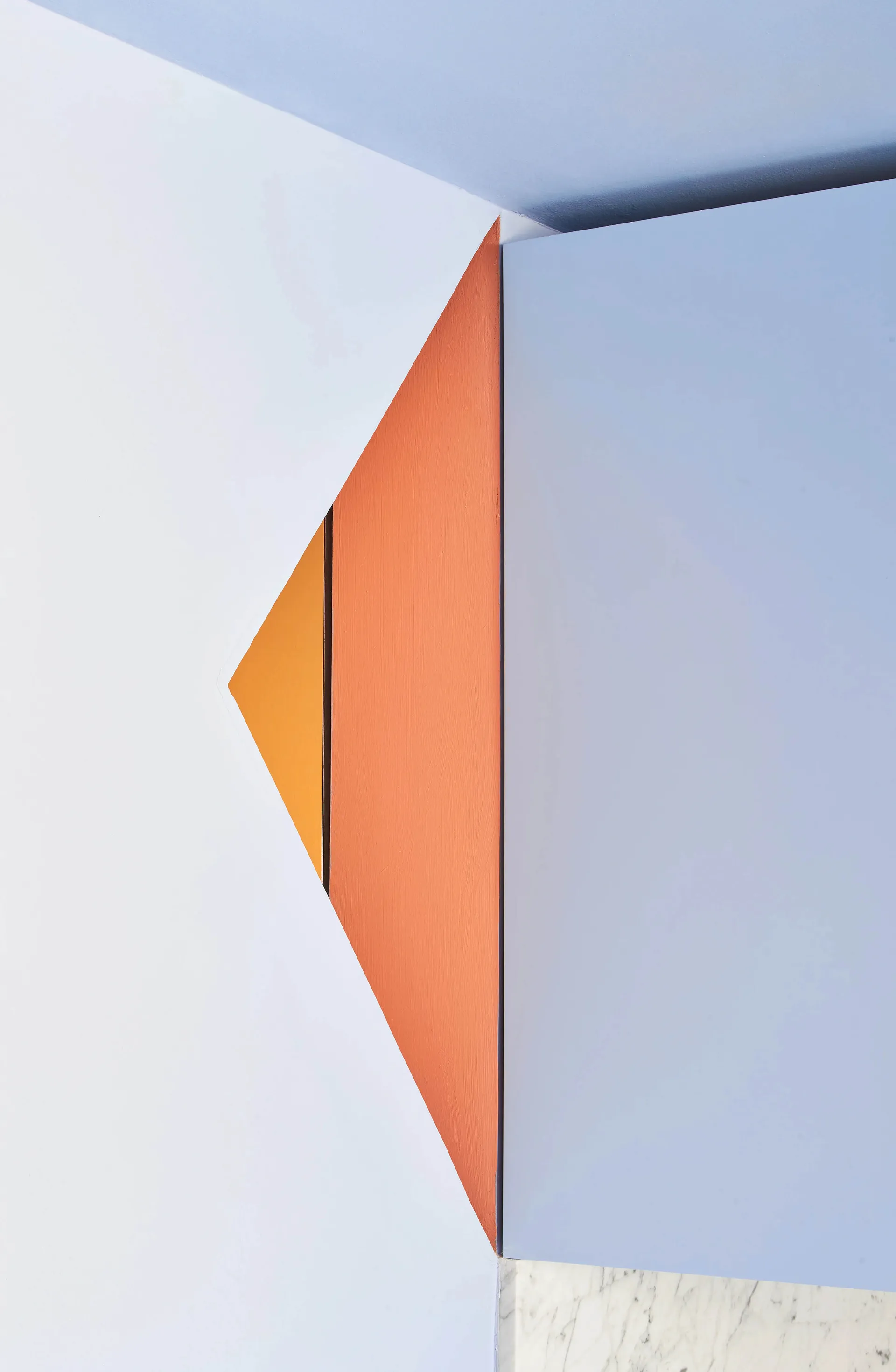 Minimalist interior with white walls, blue accents, and orange geometric shapes