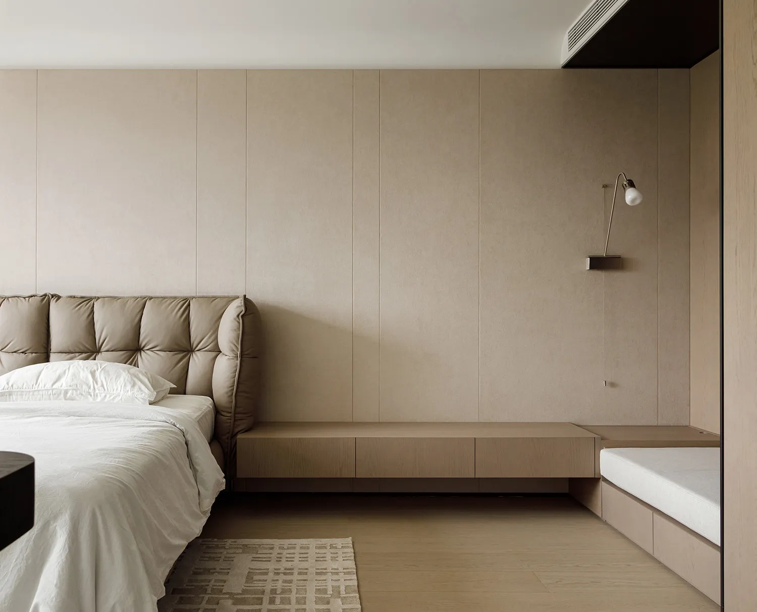 A modern minimalist bedroom featuring a wooden bed frame and headboard against a light-colored wall, with a wooden bench and