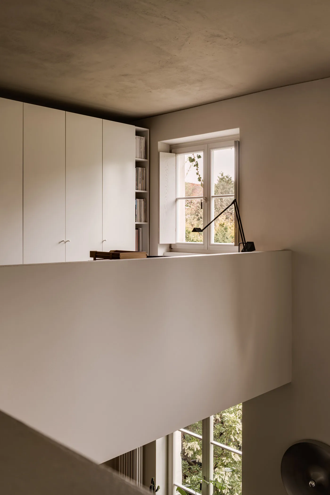 Interior view of a minimalist studio with concrete walls and open shelving.