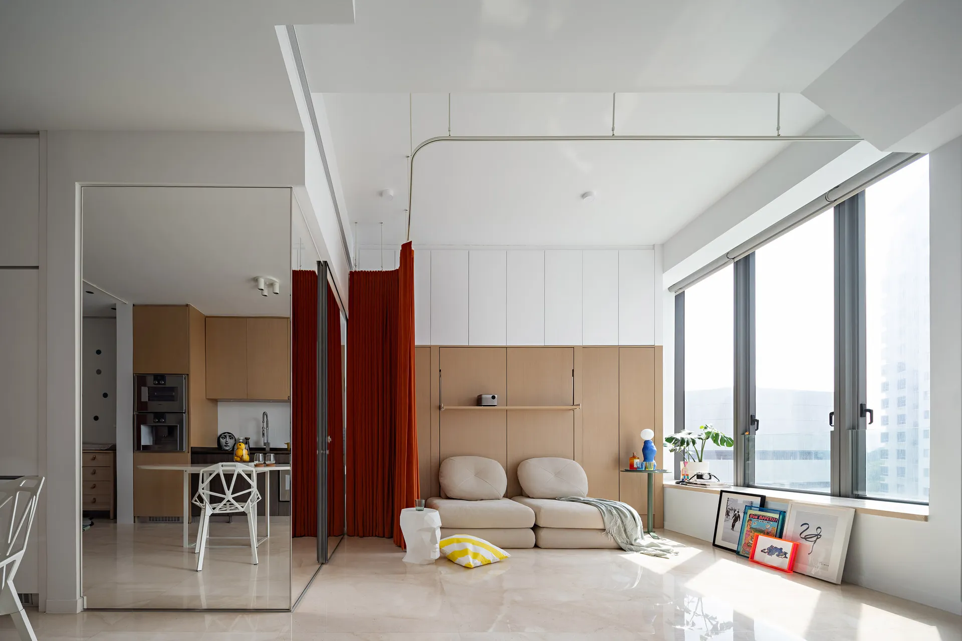 Modern living room with a glass window, white walls, wooden accents, and a comfortable seating area.