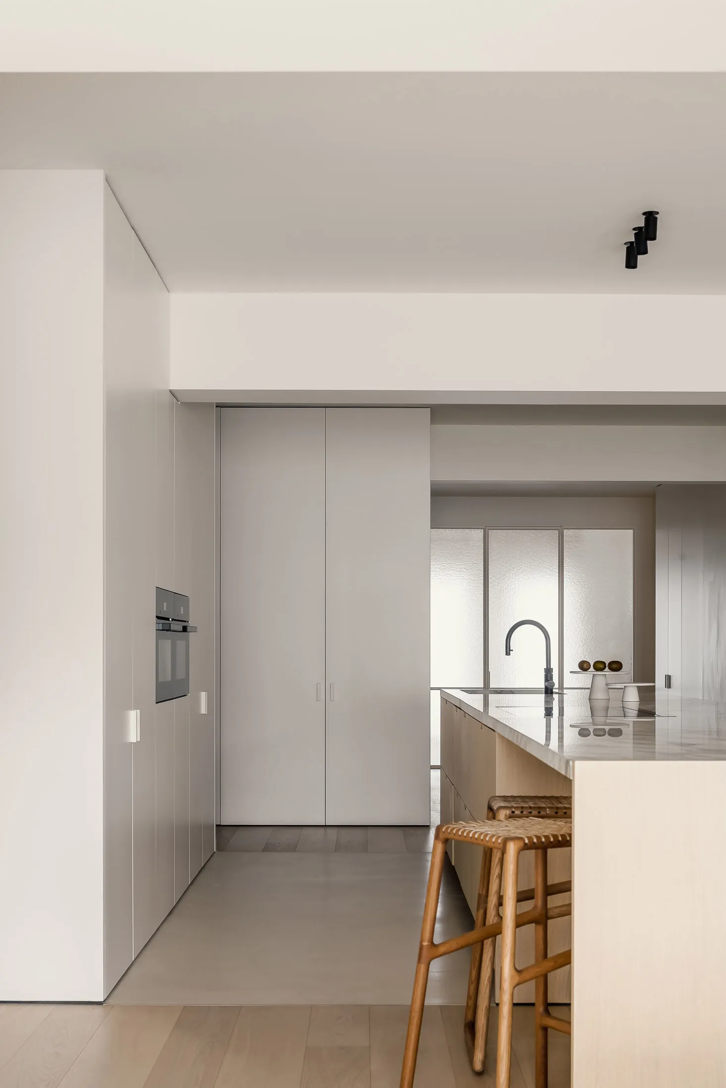 Modern minimalist kitchen with light wood elements and a sleek, clean design.