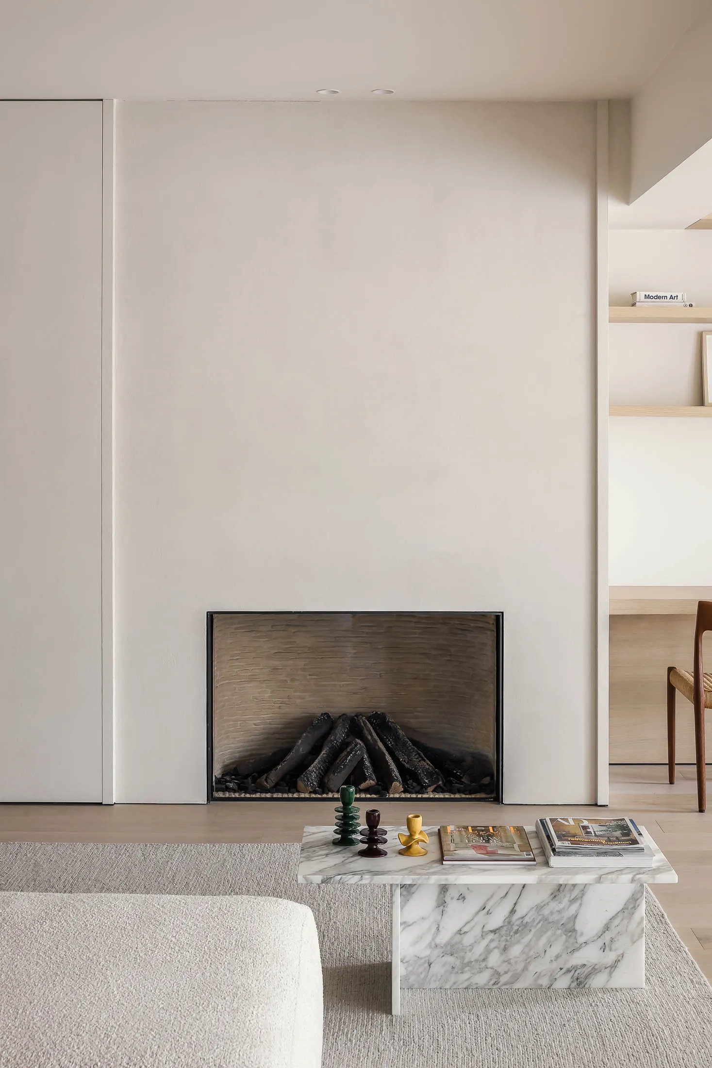 A modern minimalist living room featuring a marble fireplace and contemporary furniture
