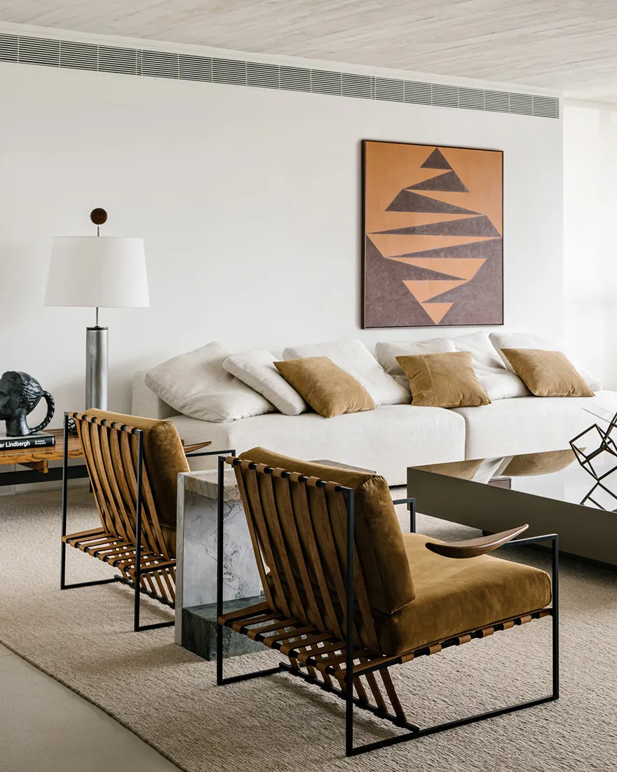 Modern minimalist living room featuring textured furniture and a geometric wall art.