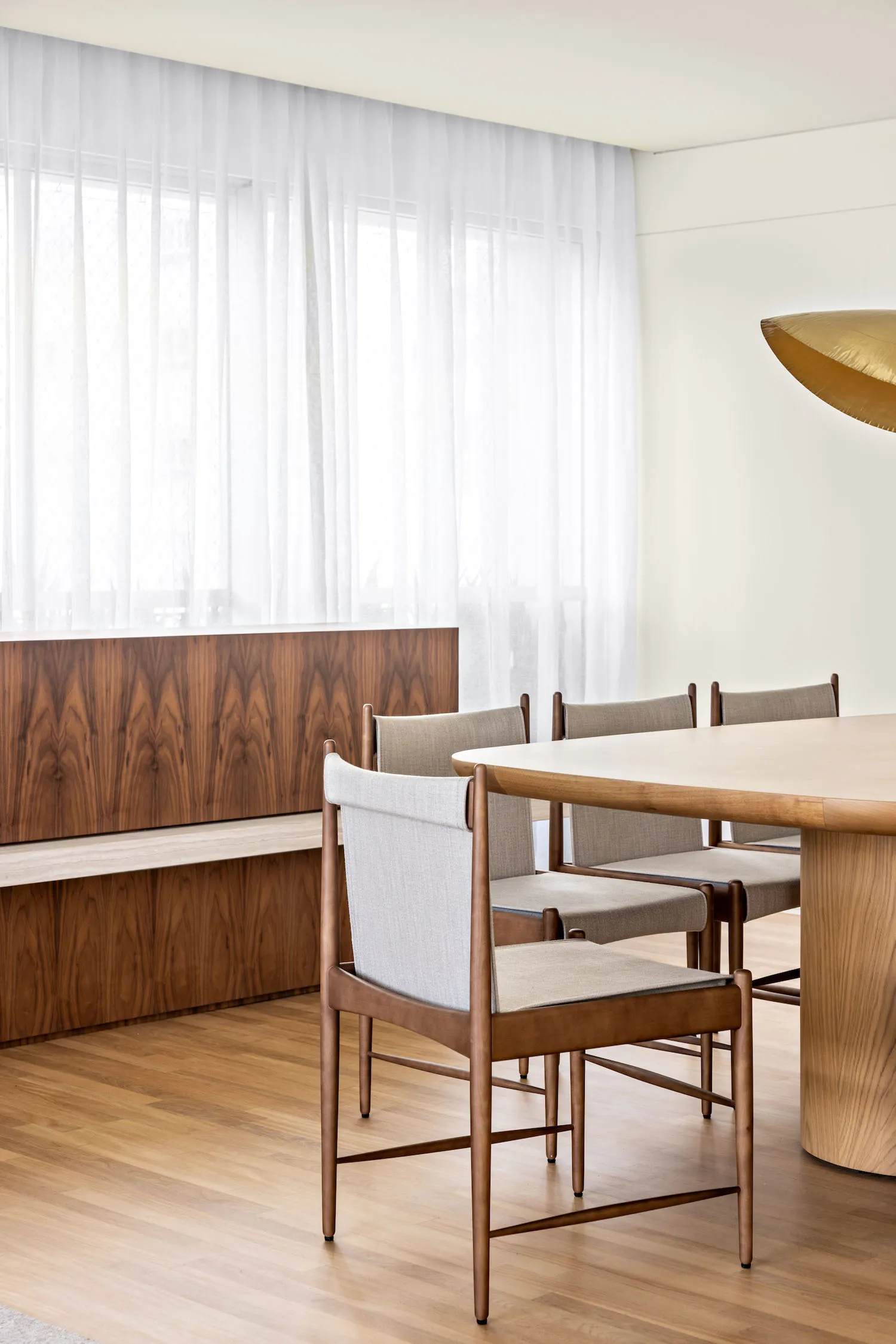 A modern residential dining room featuring a wooden table and chairs.