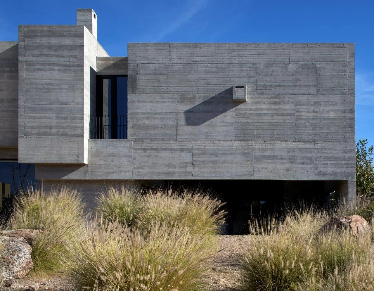 A minimalist building with a concrete exterior, featuring clean lines and a simple design.