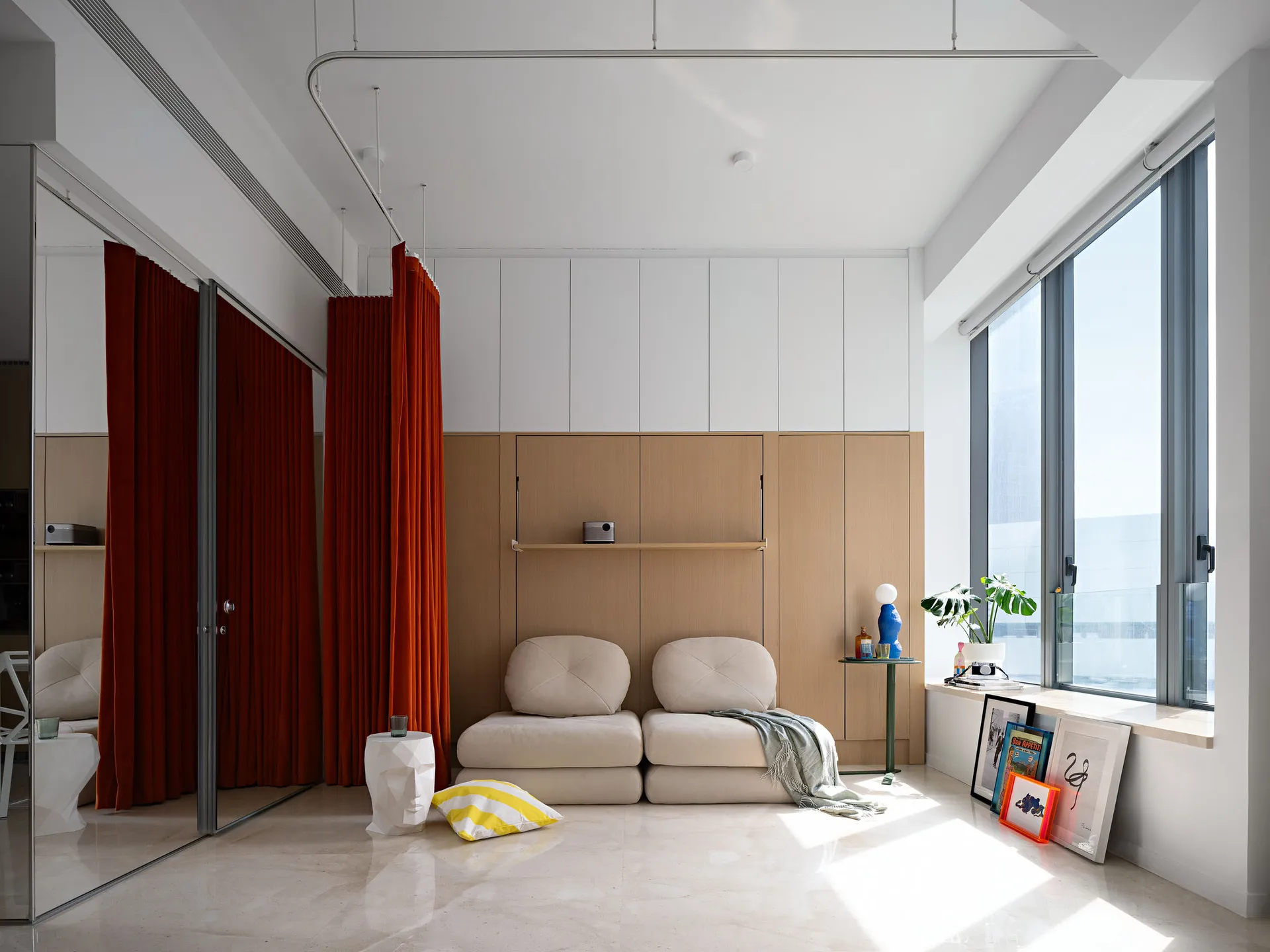 A modern living room featuring minimalist furniture, wooden paneling, and a mix of materials.
