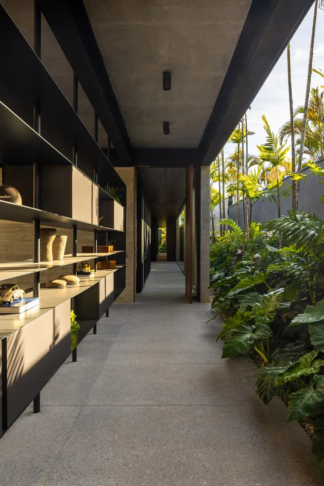 現代走廊採用混凝土地板與牆面，內建層架與綠植沿牆排列。